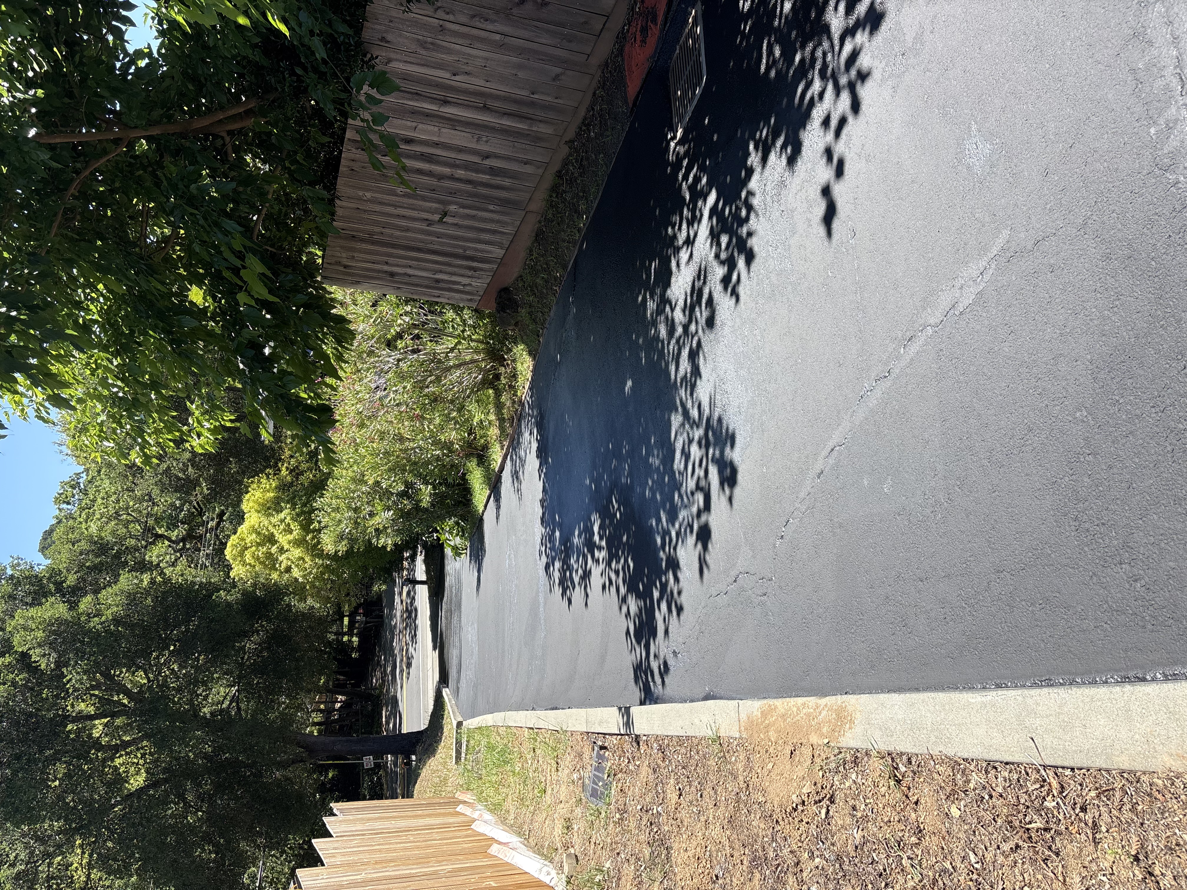 Deep black freshly sealed residential driveway after sealcoating