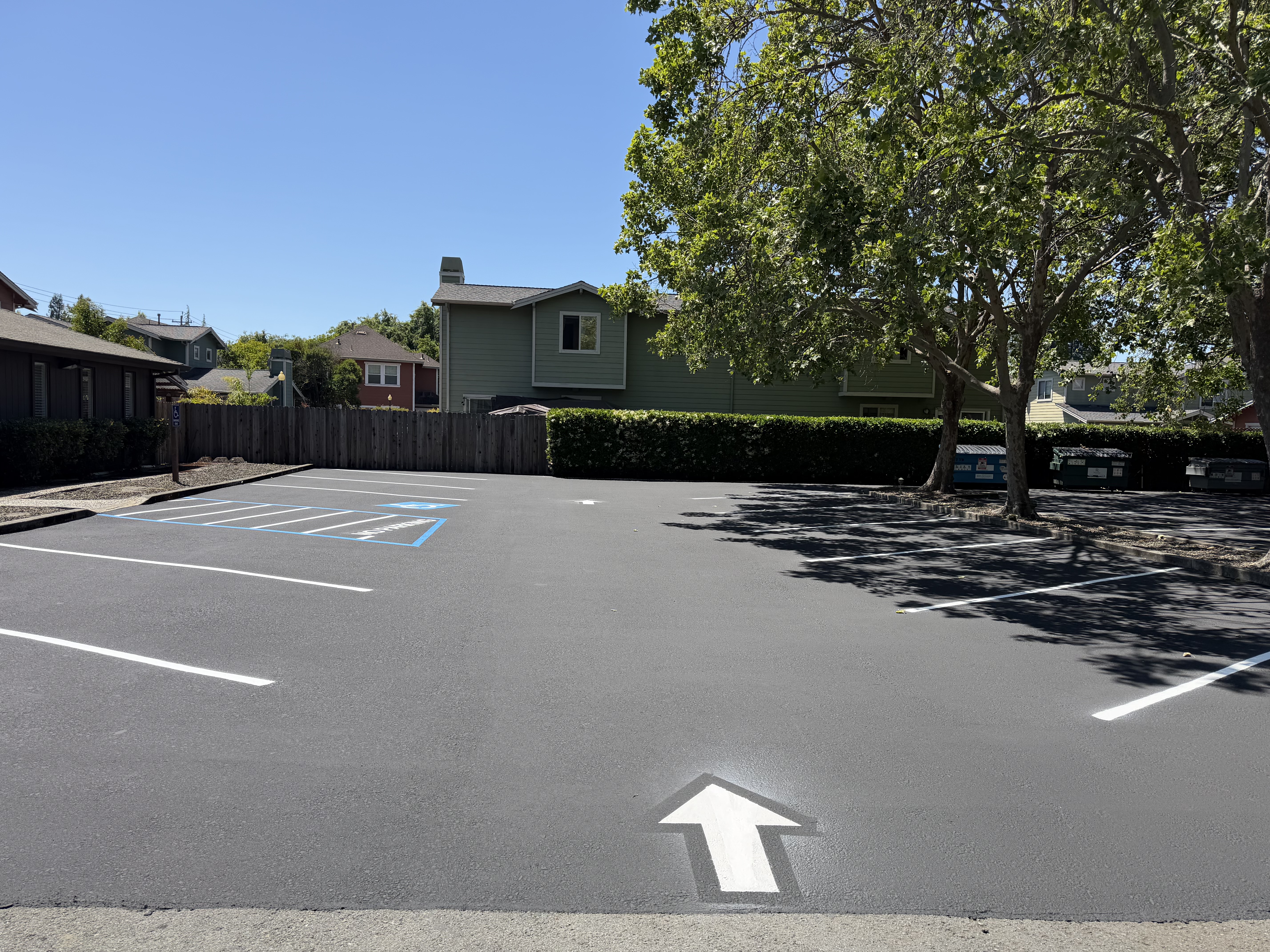 Freshly paved parking lot with ADA striping and directional arrows
